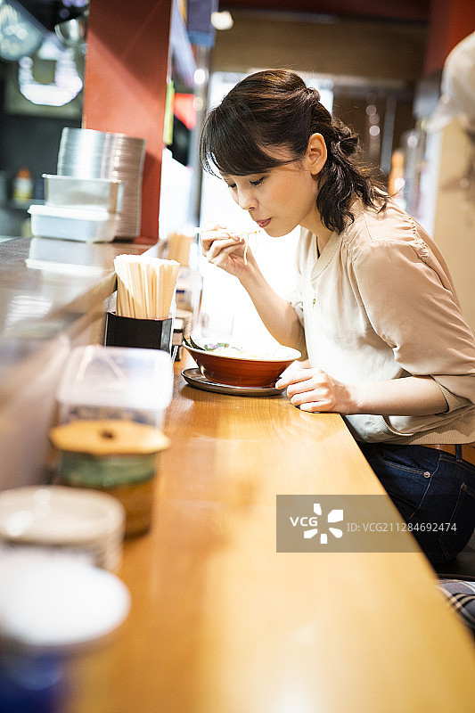 一位独自享用拉面的女人图片素材
