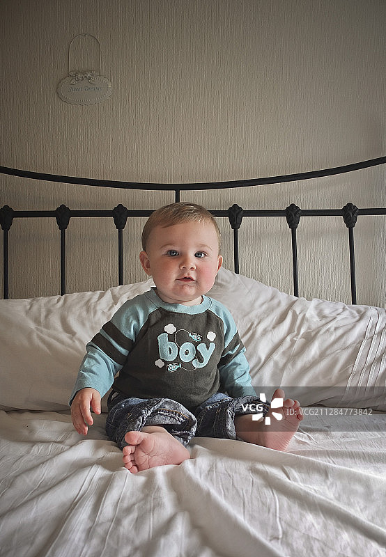 坐在床上的小男孩图片素材