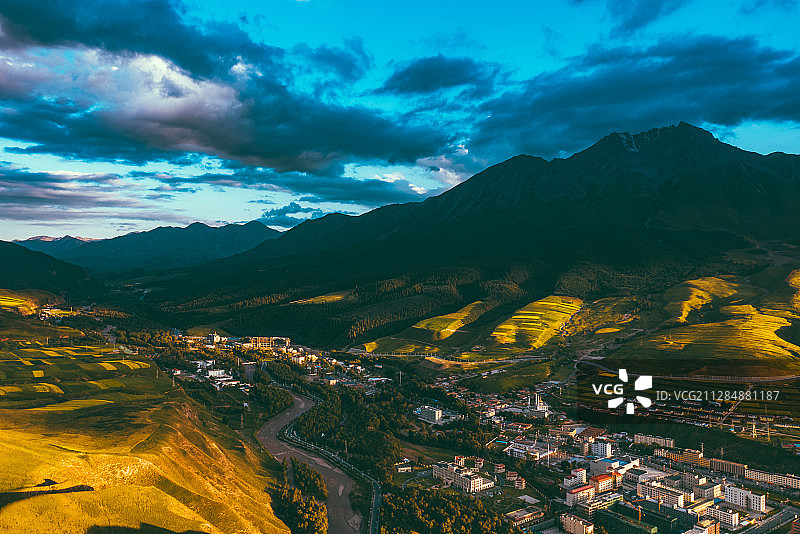 航拍夕阳下的中国青海省海北藏族自治州祁连县县城与牛心山图片素材