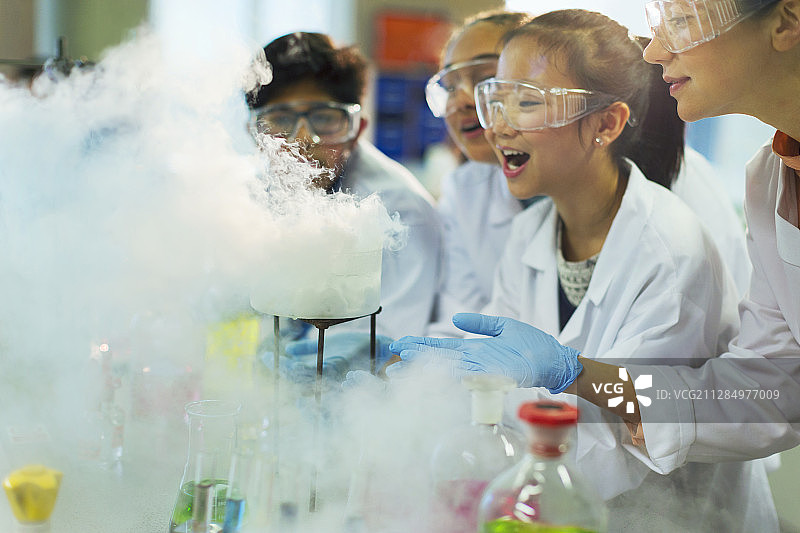 惊讶又好奇的学生们观看化学反应，在实验室课堂上进行科学实验图片素材