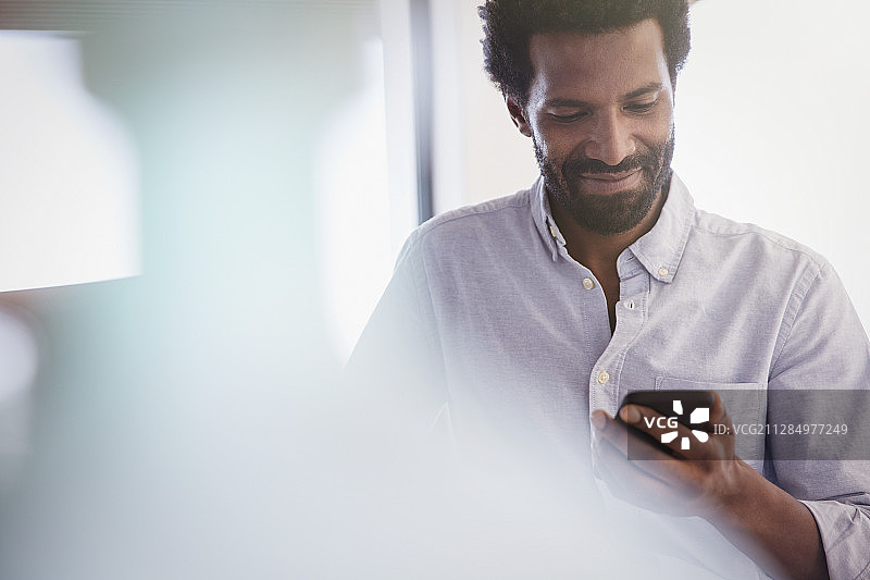 微笑的男人用手机发短信图片素材