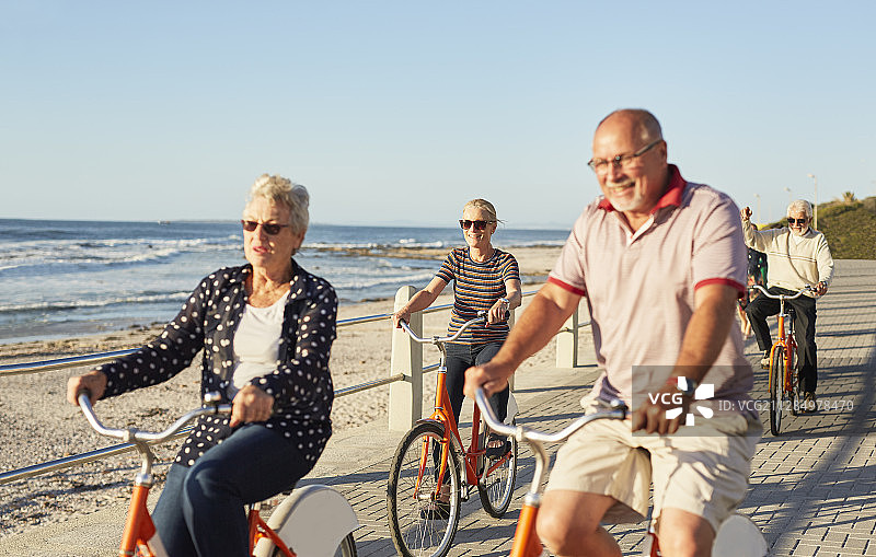 积极锻炼的老年朋友海边骑自行车图片素材