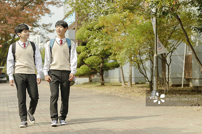 高中生的日常生活：亚洲青少年学生在大学里和朋友们一起穿着校服图片素材