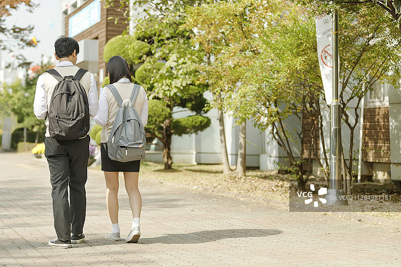 高中生的日常生活：亚洲学生穿着校服与朋友在大学里图片素材