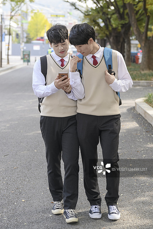 高中生的日常生活：亚洲青少年学生穿着校服与朋友在大学里图片素材