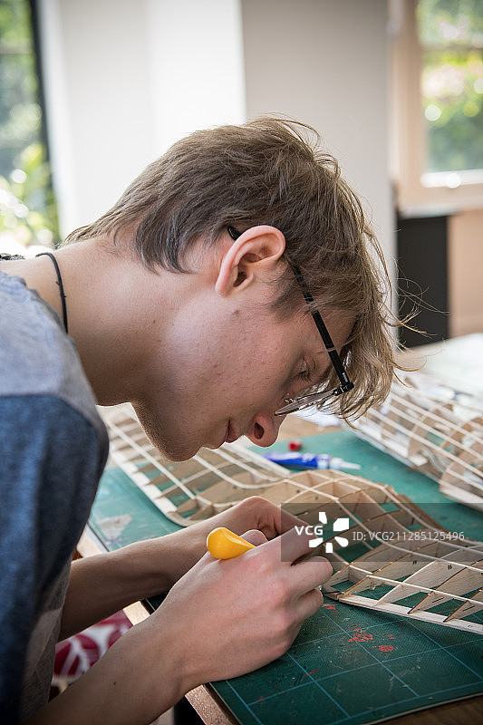 制作飞机模型的青少年男孩图片素材