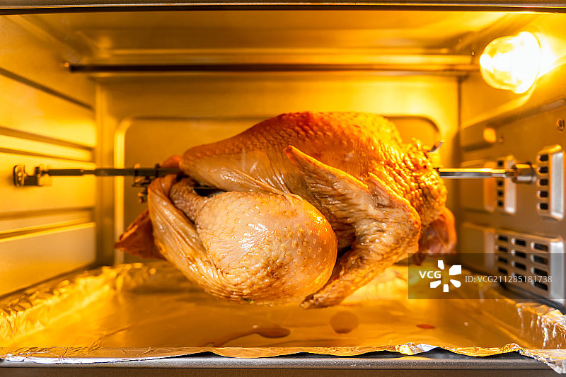 一只正在烤箱中进行烘烤的鸡图片素材