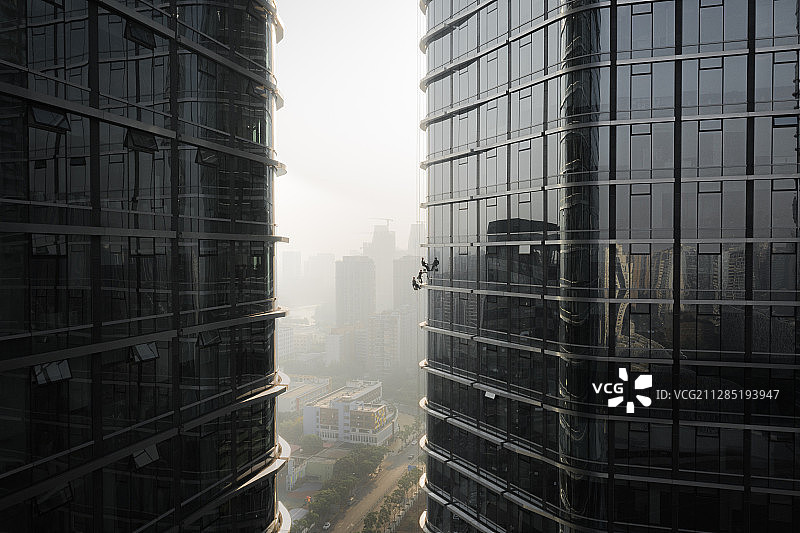 三名大厦清洁工悬吊在办公楼外图片素材