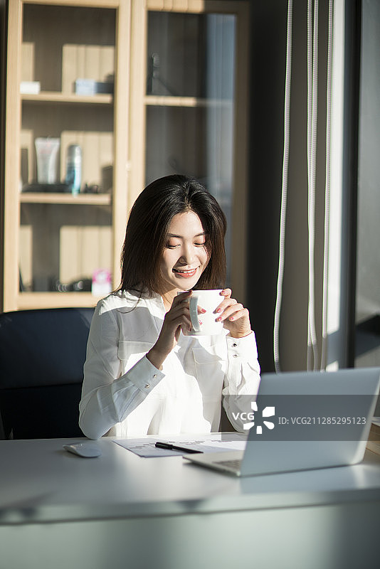 年轻商务女士在办公室喝咖啡图片素材
