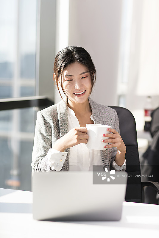 年轻女子喝咖啡轻松办公图片素材