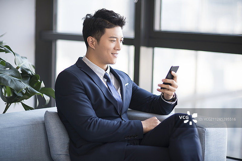 成功年轻商务男子使用智能手机图片素材