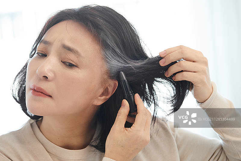 染发的中年妇女：灰发，衰老，压力，不满图片素材