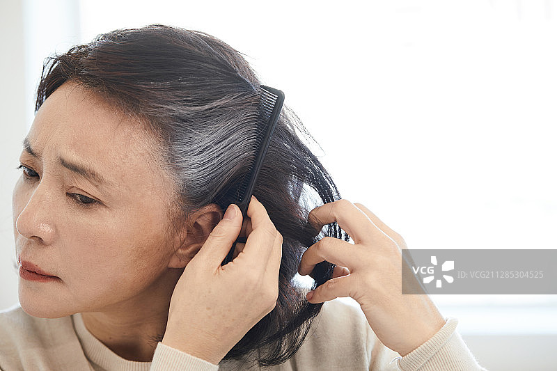 染发的中年妇女：灰发，衰老，压力，不满图片素材