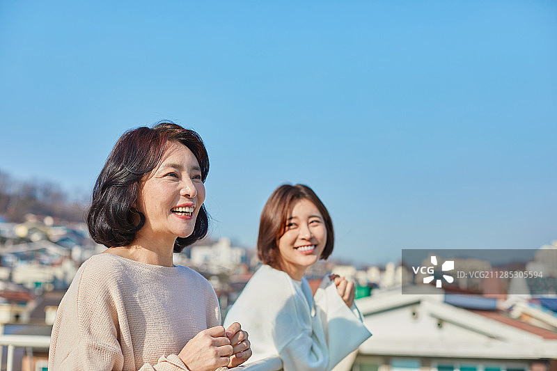 母亲和女儿在屋顶花园聊天，充满希望图片素材