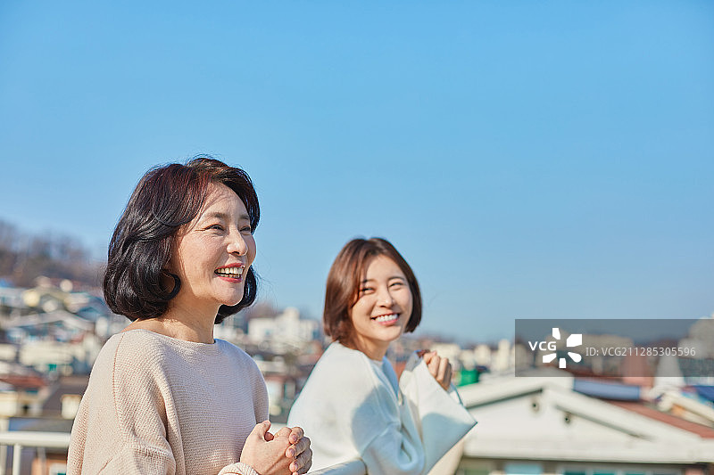 母亲和女儿在屋顶花园聊天，充满希望图片素材