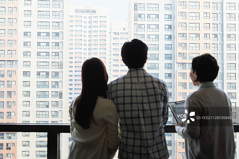房地产经纪人向新婚夫妇建议公寓相关事宜（背影剪影）图片素材
