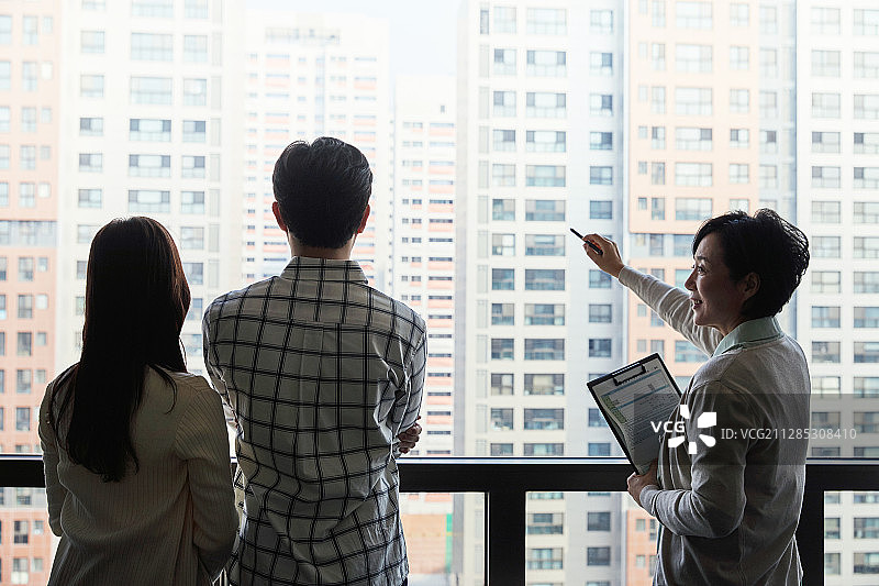 房地产经纪人向新婚夫妇建议公寓相关事宜（背影剪影）图片素材