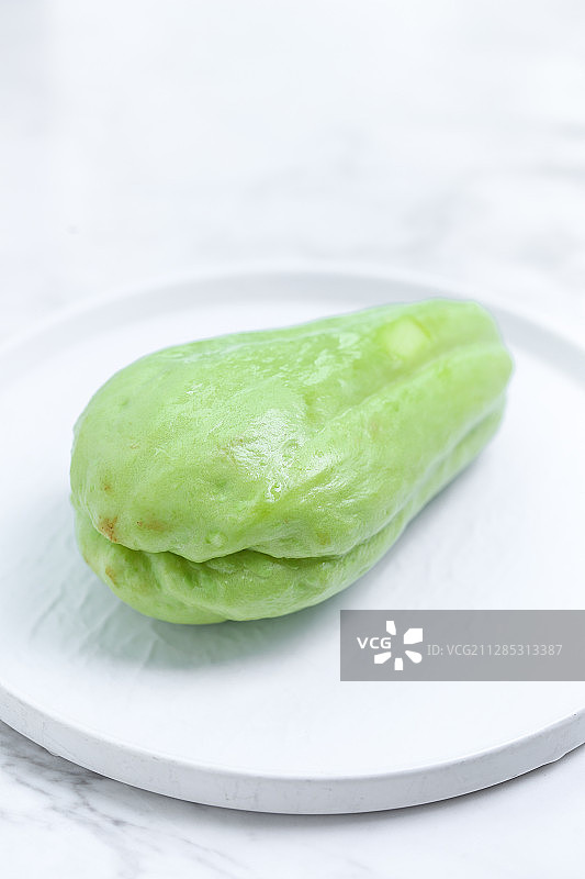 放在白色盘子里的佛手瓜图片素材