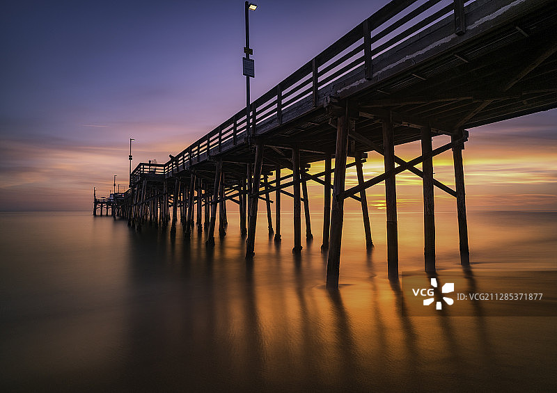 美国加利福尼亚州纽波特海滩日落时分的海洋码头图片素材