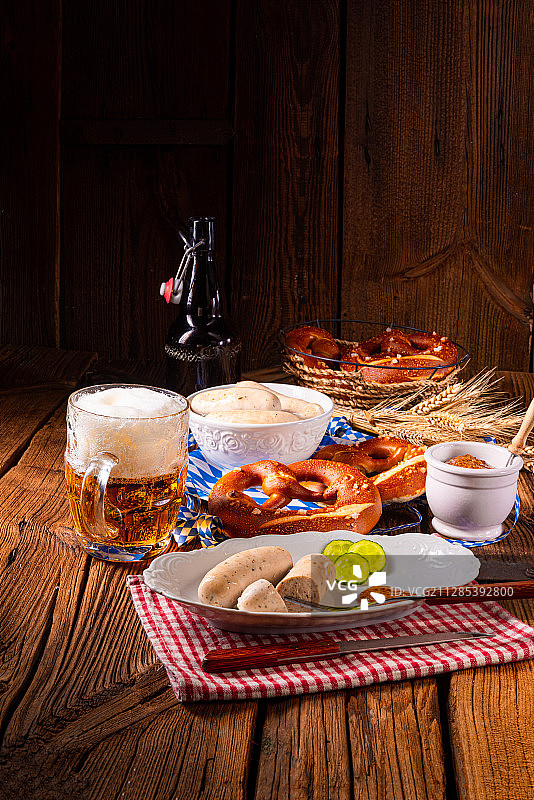 木板上的白香肠、椒盐卷饼和啤酒图片素材