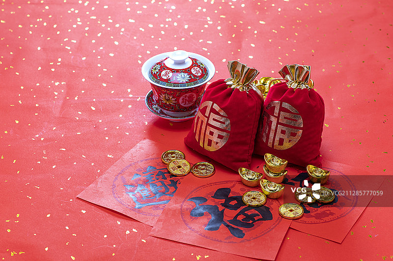 春联上放着金币元宝福袋和茶杯图片素材