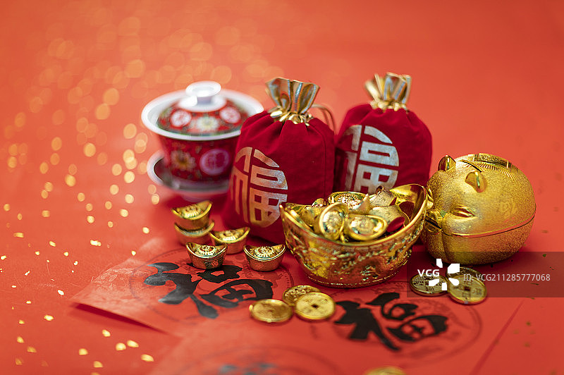 春联上放着金币元宝福袋茶杯和储蓄罐图片素材
