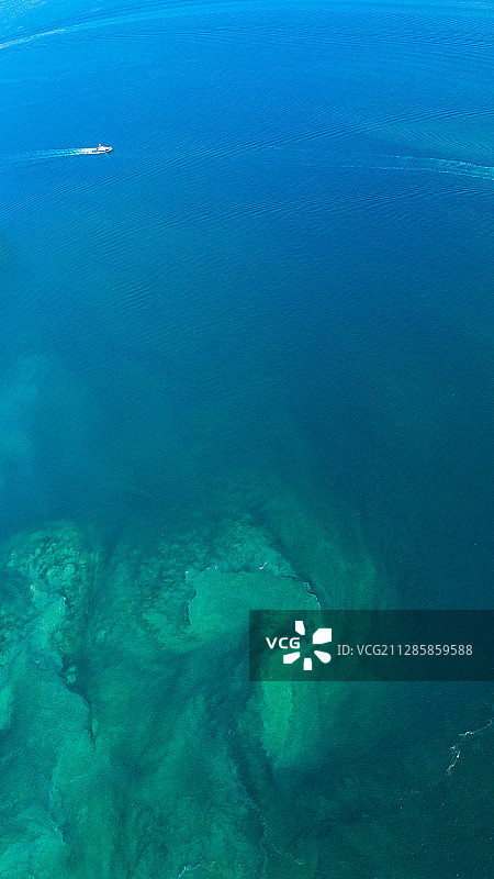 蓝色海水肌理一艘快艇驶过竖幅手机壁纸图片素材