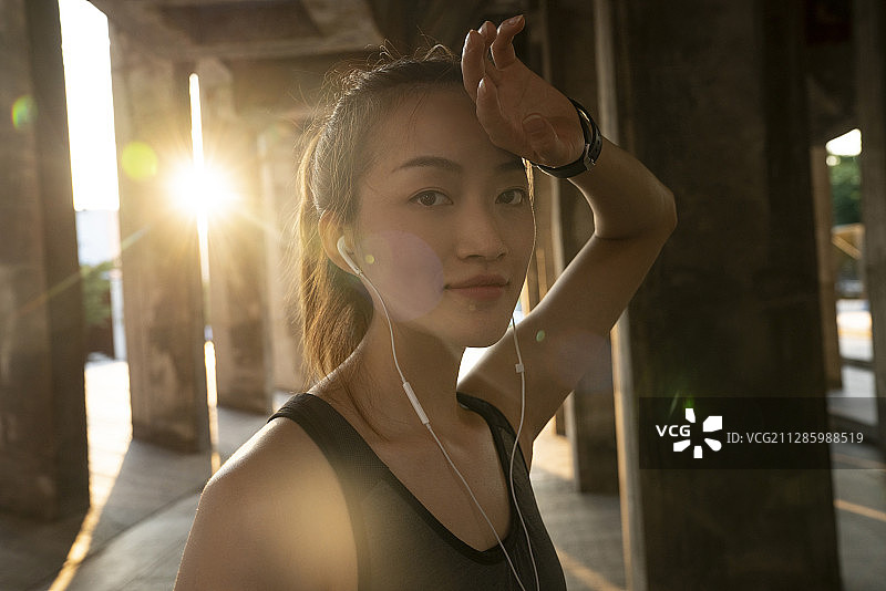戴耳机的年轻女子运动后查看运动手表图片素材