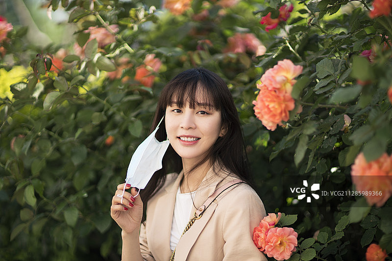 年轻女子户外郊游取下防护口罩图片素材