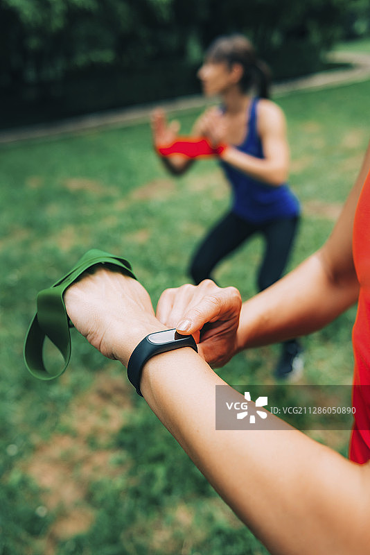 女人在户外训练后看智能手表图片素材
