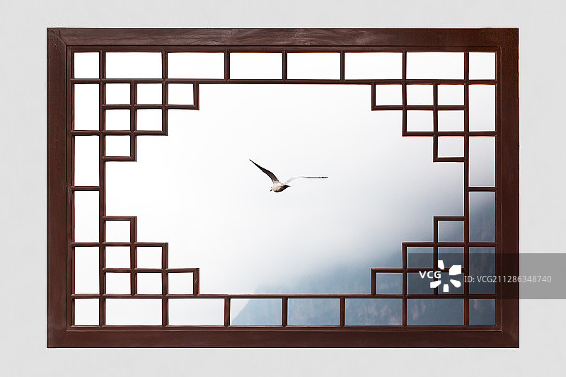 中国风传统仿古建筑窗户外远山云雾中展翅飞翔的海鸥图片素材