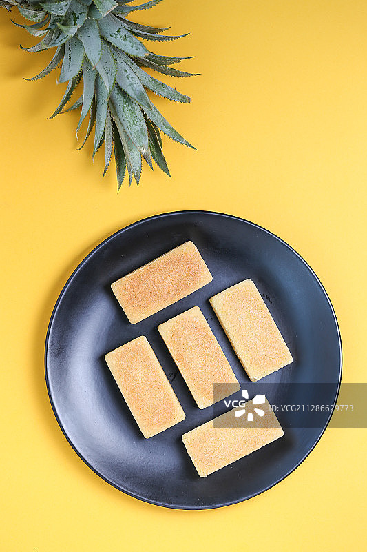 放在黄色背景上的传统中式小吃凤梨酥图片素材