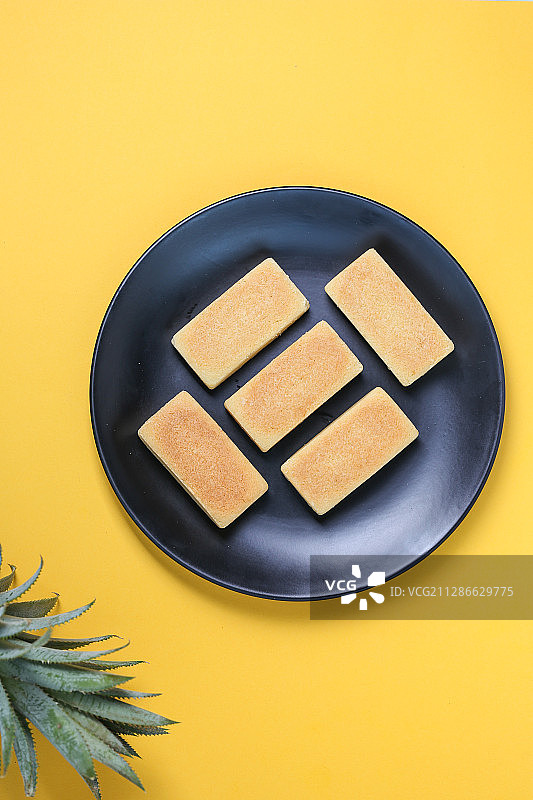 放在黄色背景上的传统中式小吃凤梨酥图片素材