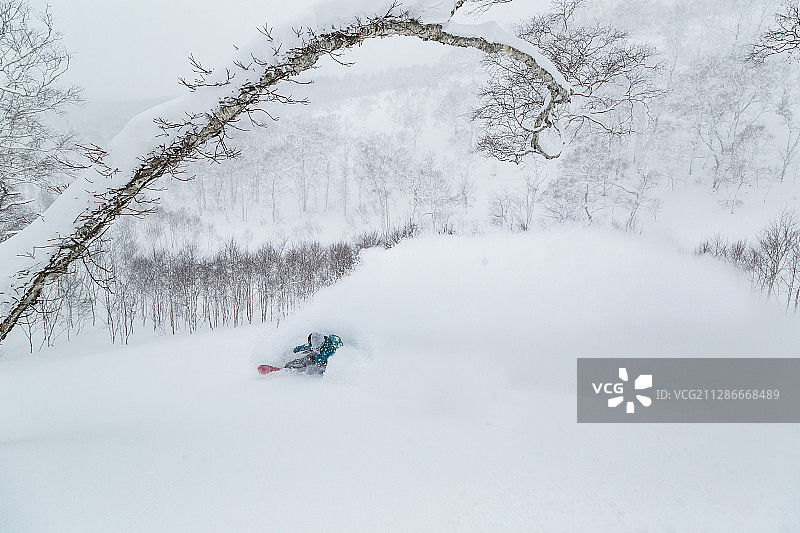 在日本北海道二世谷制造大量雪雾的奥林匹克单板滑雪运动员图片素材