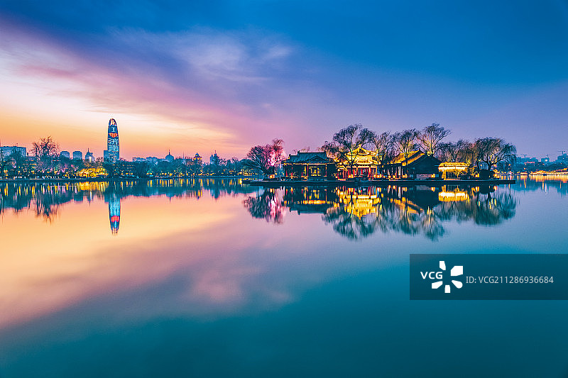 山东济南大明湖日落夜景与远处繁华城市群图片素材