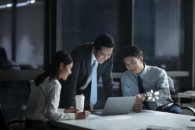 商务人士晚上加班在办公司讨论工作图片素材