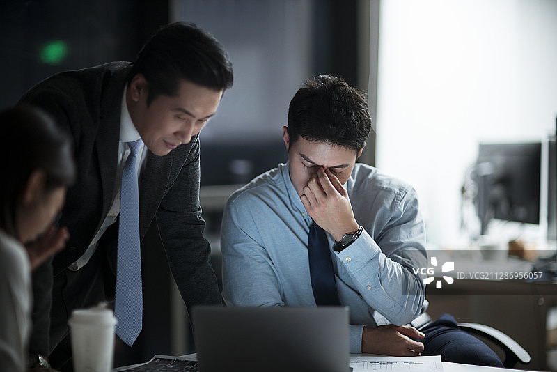 商务人士晚上加班在办公司讨论工作图片素材