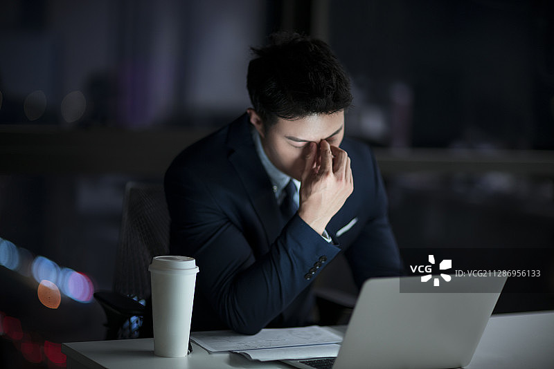 疲惫的商务男士晚上在办公室加班图片素材
