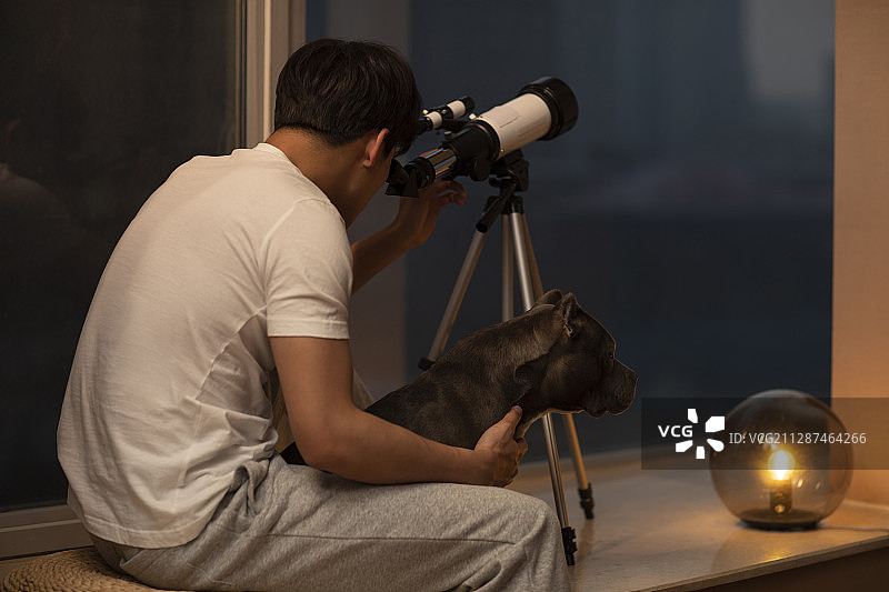 年轻男士在家使用望远镜图片素材