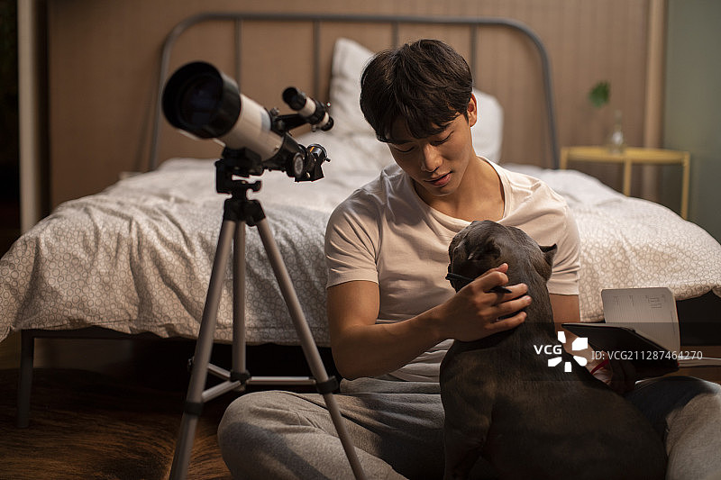 年轻男士和宠物狗在家玩耍图片素材