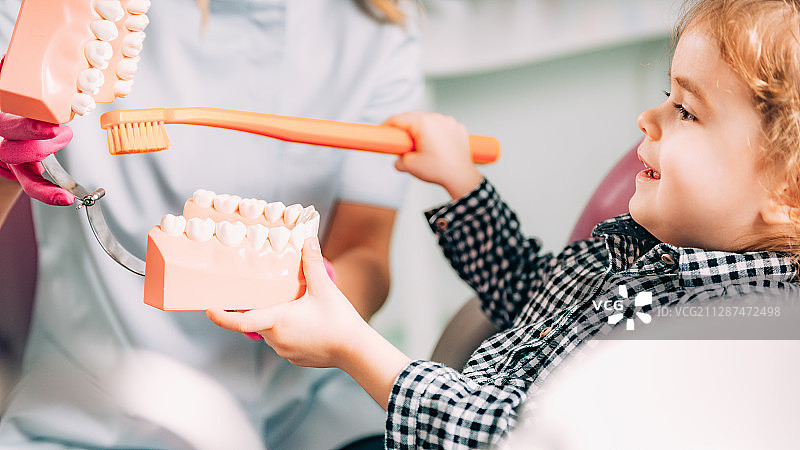 小女孩在牙科诊所学习刷牙图片素材