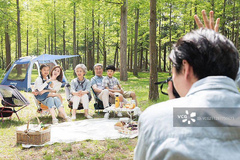 男人在森林里为露营的一大家人拍照的摄影作品图片素材