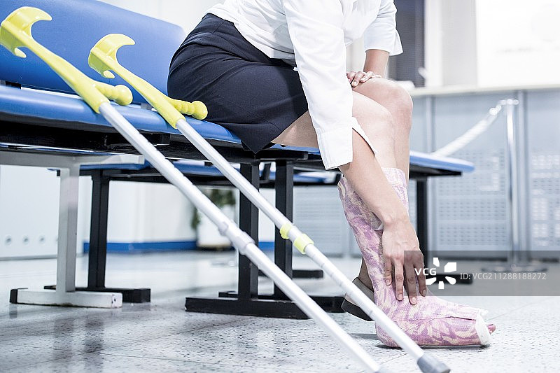 腿部打着石膏坐在椅子上的女人图片素材