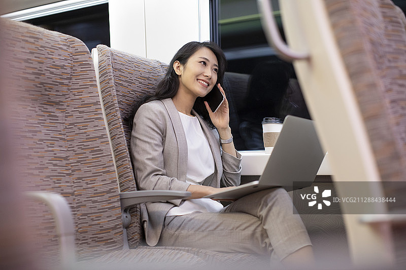 年轻商务女士在高铁上使用手机图片素材
