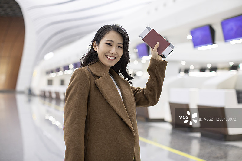年轻商务女士在机场拿着机票图片素材