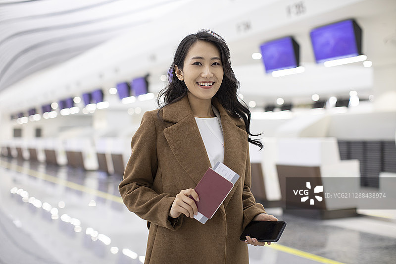 年轻商务女士在机场拿着机票图片素材