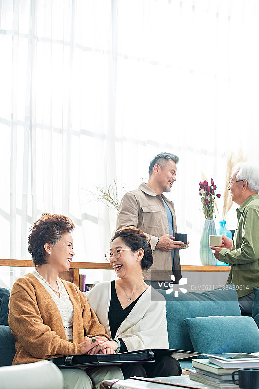 快乐的中老年朋友喝茶聊天看相册图片素材