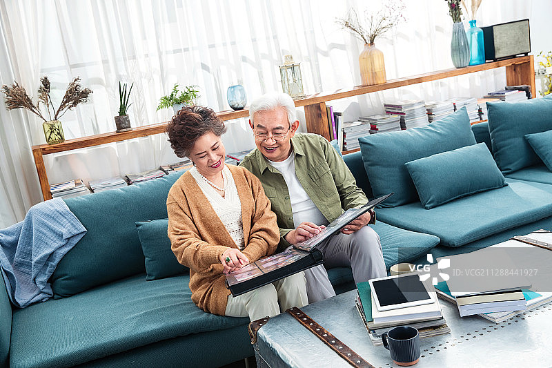 幸福的老两口坐在沙发上看相册图片素材