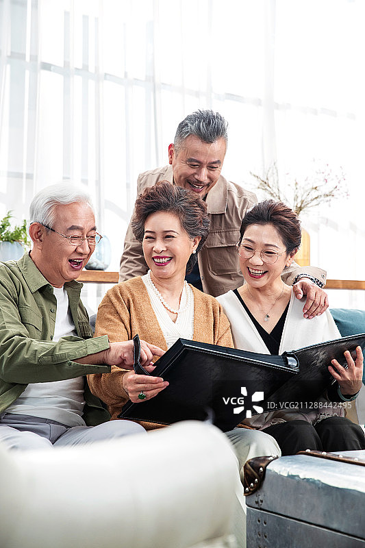 快乐的中老年朋友一起看相册回忆从前图片素材