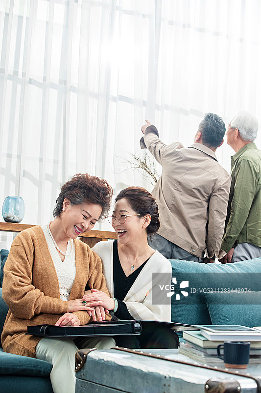中老年人们在室内聊天看相册叙旧图片素材
